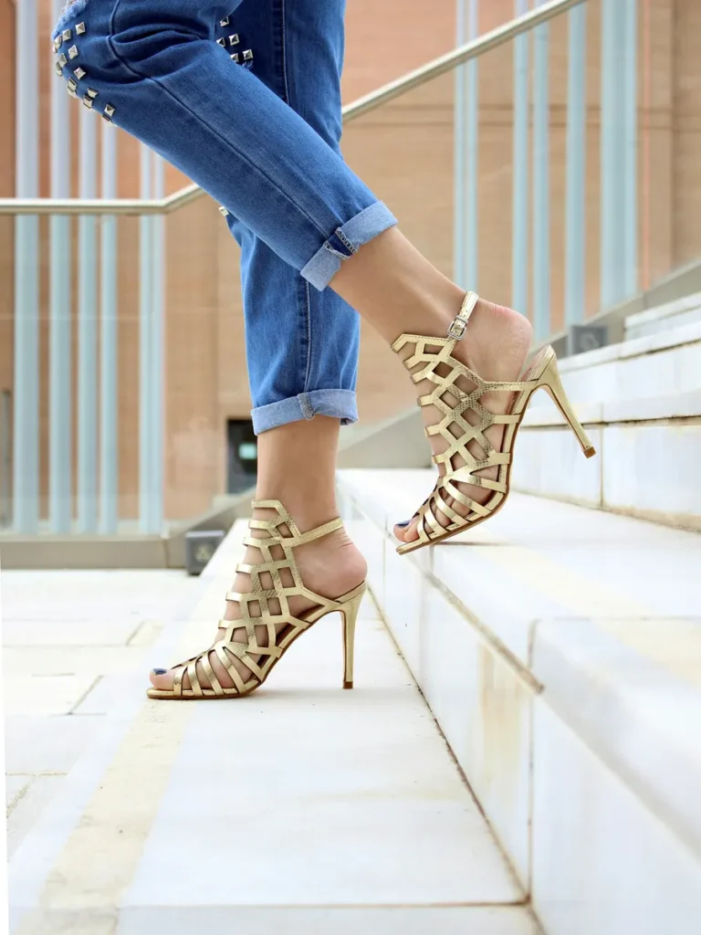 Sandalias doradas de taco en una escalera